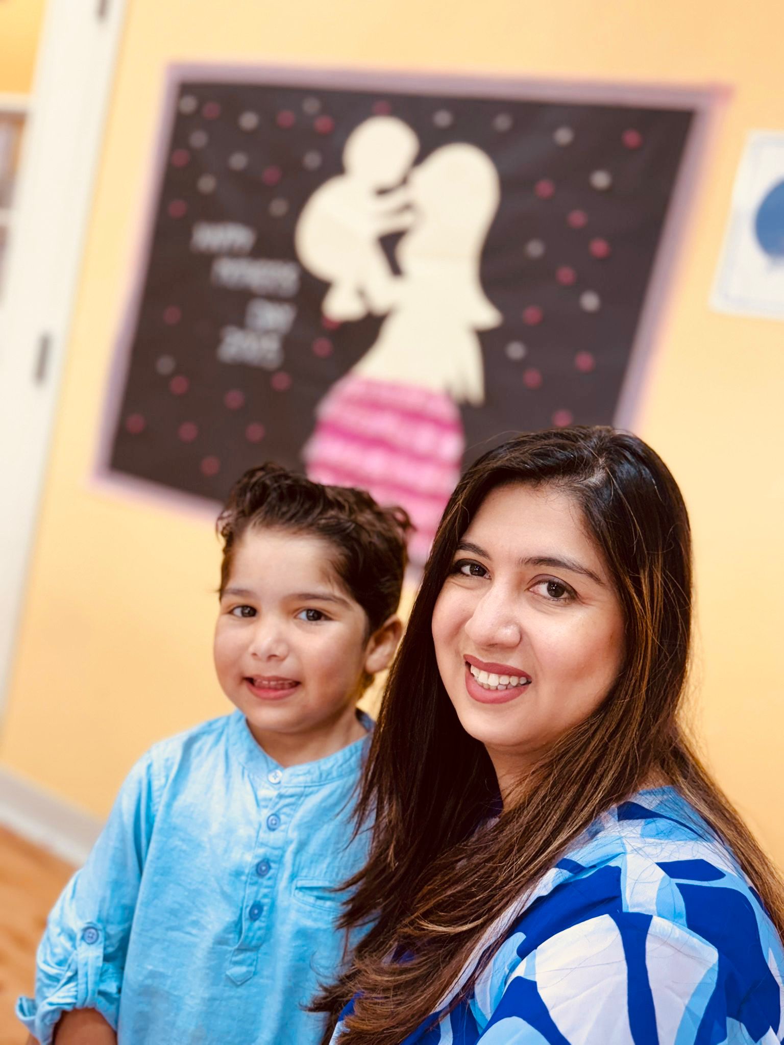 A parent and child smiling together at Creative Minds