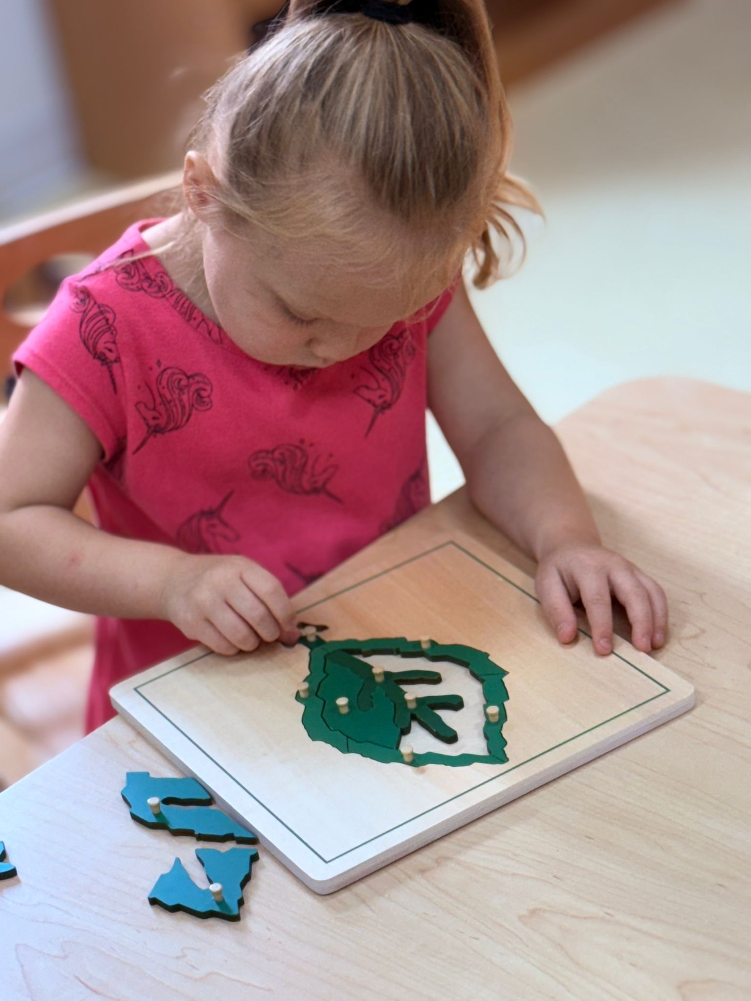 A toddler working on a letter puzzle