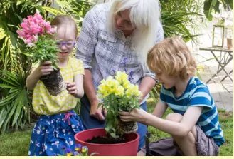 Children potting flowers together