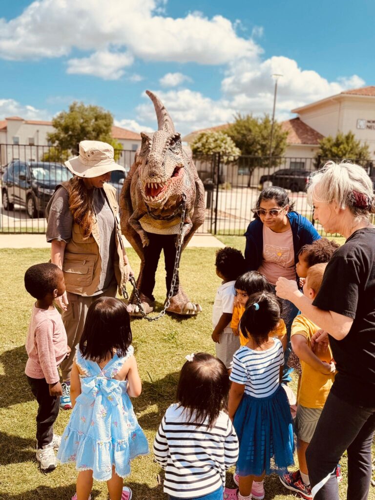 Families, teachers, and children together at a Creative Minds outdoor event